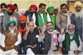  ?? ?? Activist Yogendra Yadav and Samyukta Kisan Morcha leaders flash victory signs after the farmers’ unions announced they were calling off the agitation at the Singhu border in New Delhi on Thursday.