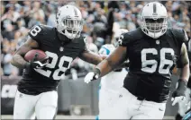  ?? Tony Avelar ?? The Associated Press Raiders running back Latavius Murray (28) runs behind guard Gabe Jackson (66) during a Nov. 27, 2016, game in Oakland, Calif. Jackson’s new contract all but ensures he will be a Raider when the team moves to Las Vegas in 2020.