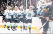  ?? ETHAN MILLER — GETTY IMAGES ?? The Seattle Kraken celebrate a goal by Ryan Donato, front, the first in franchise history, Tuesday night at Las Vegas.