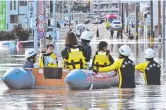  ?? Pictures: AFP; AP ?? Typhoon Hagibis left a trail of destructio­n in Ichihara, Chiba prefecture (left); and stranded residents are rescued on a rubber boat in Iwaki, Fukushima prefecture.