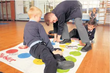  ??  ?? From left: Sharneyfor­d Primary School pupils Luke Greenwood, Noah Haislip and Matthew Carr, all 10, enjoy a game of times table Twister