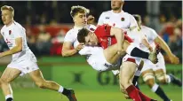  ??  ?? Over he goes: England’s Ollie Hassell-Collins is tackled by Aneurin Owen