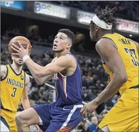  ?? DARRON CUMMINGS — THE ASSOCIATED PRESS ?? The Suns’ Devin Booker goes to the basket against the Pacers’ Myles Turner, right, during the second half of Friday’s win in Indianapol­is. Booker finished with a game-high 35points.
