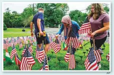  ?? AP ?? Cedar Grove High School students install a flag for each of the 2,977 people killed in the 9/11 terrorist attacks two decades ago.