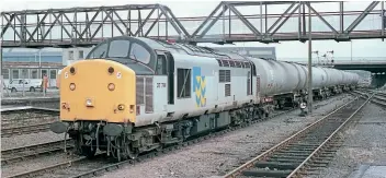  ?? ?? Although carrying Metals sector decals, No. 37714 is pictured passing Lincoln on July 15, 1993 with a westbound tanker train from Lindsey Oil Refinery.