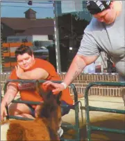  ??  ?? Tiffany Sullivan and friend enjoy watching animals at the petting zoo corral.