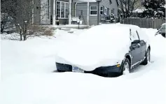  ?? JULIE JOCSAK/STANDARD STAFF ?? A car is snowed in on a St. Catharines street Wednesday.