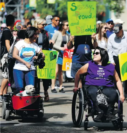  ?? LEAH HENNEL ?? Kiran Dhaliwal, left, and her dog Max take part in the Disability Pride Parade along Stephen Avenue on Sunday. .