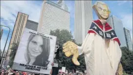  ?? AFP ?? Protestors hold a picture of Heather Heyer, who was killed during violence at a white nationalis­t rally, and a puppet of US Attorney General Jeff Sessions during a march in Chicago.