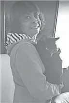  ?? SOMERS SUBMITTED BY LINDA ?? Linda Somers of Mansfield holds Onyx the cat after the feline escaped a motel room and lived in the building’s crawlspace for 36 days. The cat’s owner Allison Copeland drove 19 hours from Colorado to be reunited with Onyx on Dec. 8.