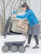  ??  ?? GOURMET GIZMO: A woman takes delivery of food from a six-wheeled robot in Tallinn, Estonia.