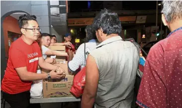  ??  ?? Meals to heal: Cheah and Kechara Soup Kitchen members handing out food to the homeless.