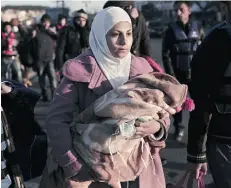  ?? ANGELOS TZORTZINIS/Agence France- Presse/Gett y Images ?? A migrant from Syria holds her child upon arrival in Greece at the port of Lesbos on Thursday.