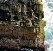  ?? ?? Trapped: Rescuer abseils down cliff