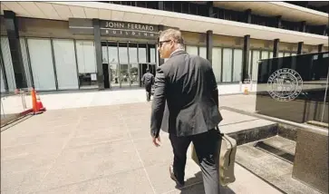  ?? Al Seib Los Angeles Times ?? AN FBI AGENT enters the downtown headquarte­rs of the Los Angeles Department of Water and Power on Monday. The FBI also served warrants at City Atty. Mike Feuer’s City Hall offices and two other locations.