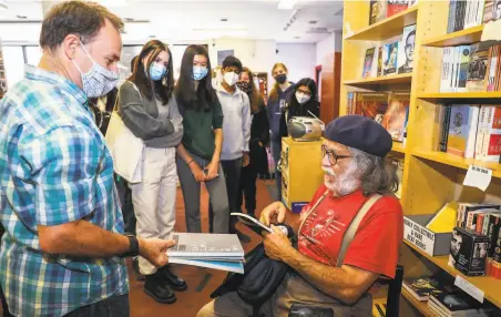  ?? Yalonda M. James / The Chronicle ?? Charles Shuttlewor­th (left), a teacher at San Jose’s Harker School, hands books to poet Neeli Cherkovski at the Beat Museum.