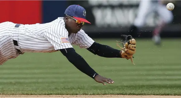  ?? KATHY WILLENS/THE ASSOCIATED PRESS ?? The ball skips past the best efforts of Yankees shortstop Didi Gregorius on Kevin Pillar’s ninth-inning grounder during matinee action Tuesday in the Bronx. The Jays went on to win, 4-1.