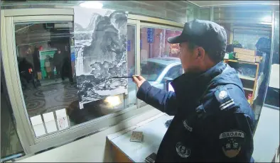  ?? GAO ERQIANG / CHINA DAILY ?? Ma Yibao paints on rice paper while working in the guard booth at a residentia­l complex in Shanghai.