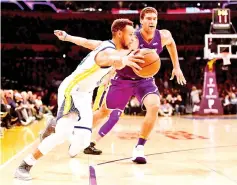  ?? — AFP photo ?? Stephen Curry (L) of the Golden State Warriors dribbles around Brook Lopez of the Los Angeles Lakers during the first half at Staples Center on November 29, 2017 in Los Angeles, California.