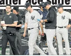  ??  ?? THE BIG HURT: Gerrit Cole walks off the mound with a trainer after being pulled in the fourth inning with a hamstring injury.