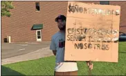  ?? John Popham ?? Jesse Burnette holds up a sign that reads “Lord have mercy, Christ have mercy, Lord have mercy on us,” during Friday night’s candleligh­t vigil held by Turn Your Back on Hate and Romanos Unidos.