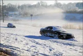  ?? AP PHOTO/MATT BELL ?? Cars are covered by snow in Martinsvil­le, Va., Sunday, March 25, 2018. The NASCAR Cup Series race at Martinsvil­le Speedway was postponed until Monday because of inclement weather.