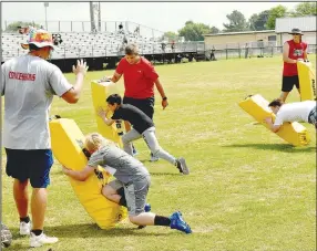  ??  ?? Learning to tackle correctly is a basic football skill taught at last week’s annual Prairie Grove pee wee football camp.