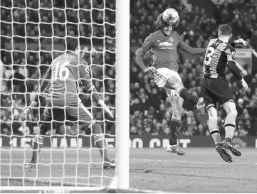  ?? — Reuters photo ?? Manchester United’s Marouane Fellaini (centre) scores the second goal during the League Cup semi-final first leg match against Hull City at Old Trafford.