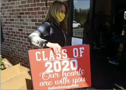  ?? BEN HASTY —MEDIANEWS GROUP ?? Denise Benfield holds a sign that she and Carrie McCarty had printed to honor graduating seniors who will not have a graduation ceremony because of the coronaviru­s outbreak.