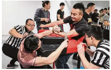  ?? — AFP ?? Strong-arm tactics: Participan­ts competing in the 7th Shanghai Arm Wrestling Open in Shanghai.