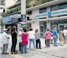  ?? MILOS BICANSKI/GETTY IMAGES ?? Greeks queue Sunday in front of the National Bank in Athens hoping to be able to withdraw euros. Banks and stock markets will close for several days, the government announced Sunday.