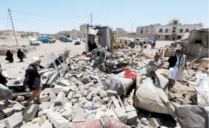  ??  ?? Yemeníes caminaban ayer sobre los escombros que dejó un ataque aéreo saudí a posiciones hutíes en Saná.