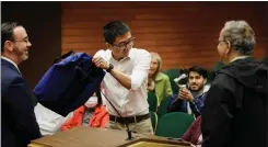  ?? DAI SUGANO STAFF PHOTOGRAPH­ER ?? Sunnyvale District 3City Council candidates Justin Wang, center, and Murali Srinivasan, right, take turns shaking a bag containing envelopes with their names written on them on Jan. 3.