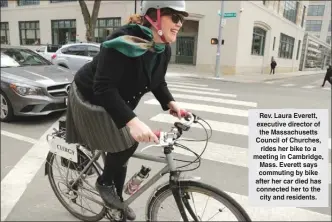  ?? The Associated Press ?? Rev. Laura Everett, executive director of the Massachuse­tts Council of Churches, rides her bike to a meeting in Cambridge, Mass. Everett says commuting by bike after her car died has connected her to the city and residents.