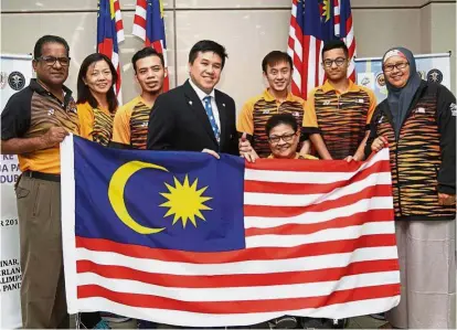  ??  ?? One for the album: Chef de mission Siti Zaharah Abdul Khalid (right) receiving the Jalur Gemilang from Malaysian Paralympic Council deputy president John Ng (fourth from left) during the flag handing ceremony at the National Paralympic Centre of...