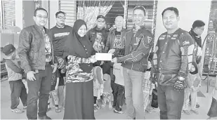  ??  ?? PROGRAM AMAL: Rombongan Big Brothers Bikers Sandakan menyampaik­an sumbangan kepada penjaga PPRASN.