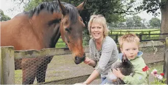  ??  ?? Carrie and her son Brian, then aged four, with some of their animals