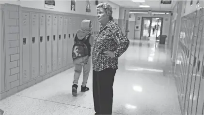  ?? SHAWN DOWD/ROCHESTER DEMOCRAT AND CHRONICLE ?? East High School superinten­dent Marlene Blocker talks with students as she walks the halls at East Lower School. Every student she encountere­d called to her by name.