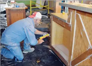  ?? TAMMY KEITH/RIVER VALLEY & OZARK EDITION ?? Gary Hartsfield, an employee at the University of Central Arkansas physical plant, caulks a cabinet in the building that is being renovated for a new program, UCA Downtown. Programs, classes and lectures will be held in the space at 1107 Oak St. in...