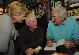  ?? Photos by Declan Malone ?? Carl O’Flaherty signing a copy of his new book ‘Dingle People’ for Mike Moriarty from Ventry, with Margo Doyle (left) at the launch in O’Flaherty’s bar on Sunday. Carl O’Flaherty with his twin brother, Fergus, and Tom Fox (left) “without whom the book...