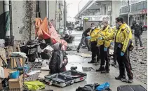  ?? CHRIS YOUNG
THE CANADIAN PRESS ?? Police officers speak to a homeless person as city workers clear an encampment on Toronto's Bay Street.