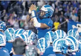  ?? STEPHEN M. DOWELL/ORLANDO SENTINEL ?? Apopka quarterbac­k Jaquan Lowman (1) cheers with teammates before the Steinbrenn­er High at Apopka High state semifinal on Nov. 29.