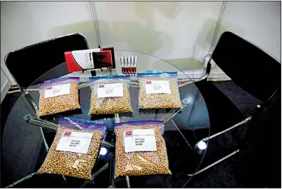  ?? AP ?? A U.S. soybean company displays its products in a booth at a 2018 internatio­nal soybean exhibition in Shanghai. China announced Wednesday that it will continue tariffs on soybeans and some other farm products.