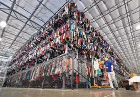  ?? MATT YORK/ASSOCIATED PRESS ?? In this 2019 photo, thousands of unwanted garments are stored on a three-tiered conveyor system at the ThredUp sorting facility in Phoenix.