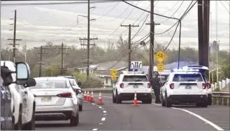  ?? ?? Police officers close a lane of Piilani Highway in Kihei Wednesday morning due to a downed line.