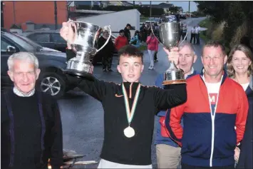  ??  ?? All-Ireland Road Bowling champion Jamie Kelleher in the company of family members at the homecoming in Kilcorney after his big win in Armagh. Picture John Tarrant