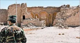  ?? GEORGE OURFALIAN/GETTY-AFP ?? A Syrian government soldier patrols Sunday at an archaeolog­ical site. In the southweste­rn part of the country, shooting stopped ahead of a cease-fire deadline, residents said.