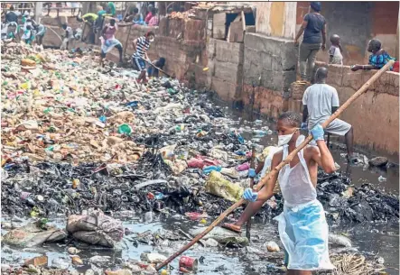  ?? — AFP ?? Working together: Residents participat­ing in the first ‘National Cleaning Day’ in Freetown.