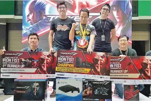  ??  ?? TERRY Wong (dua kanan) bersama Ahmad Zaharin (tengah), Yong Tze Khiong (kiri) dan Voon Khian Jin (kanan) semasa majlis penyampaia­n Pertanding­an `Game’ Tekken 7: King Of Iron Fist Borneo 2017 berakhir di The Walk, Riverson, Kota Kinabalu pada Sabtu.