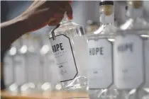  ??  ?? A WORKER puts bottles of gin on a shelf at the Hope on Hopkins distillery in Salt Riveron, on Jan. 26 in Cape Town.